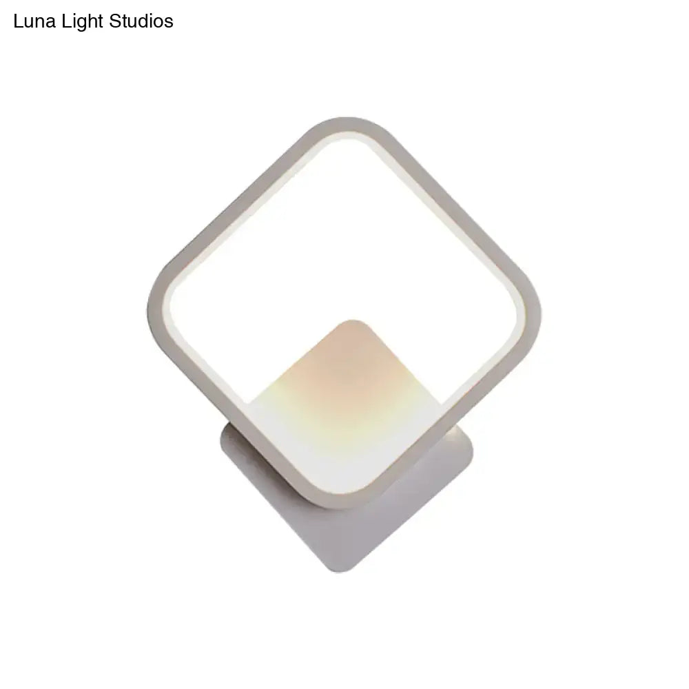 Modern white square bedside wall lamp with a black white geometric frame and soft ambient lighting for minimalist bedrooms