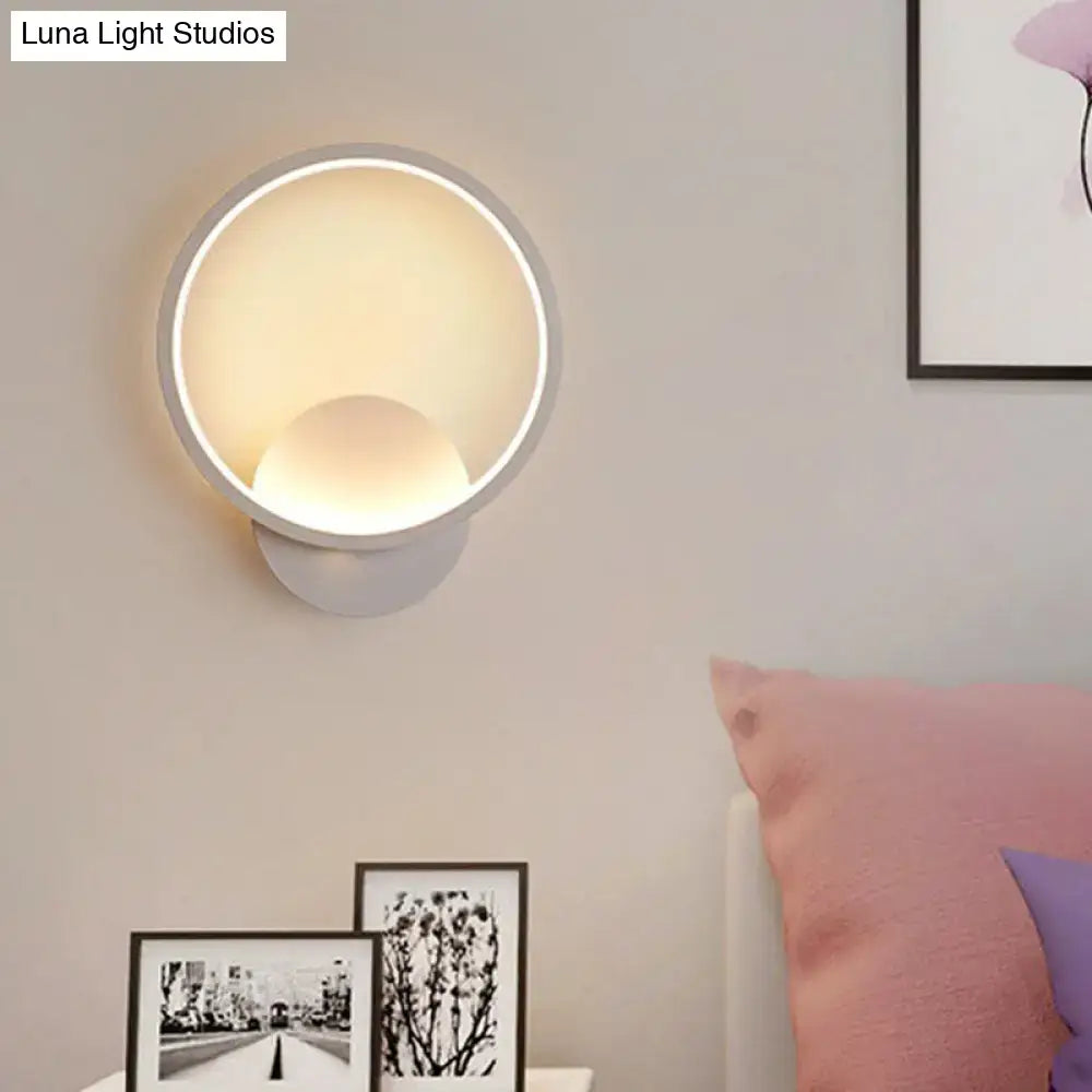 Modern white bedside wall lamp with circular design and warm diffused glow for minimalist bedroom lighting