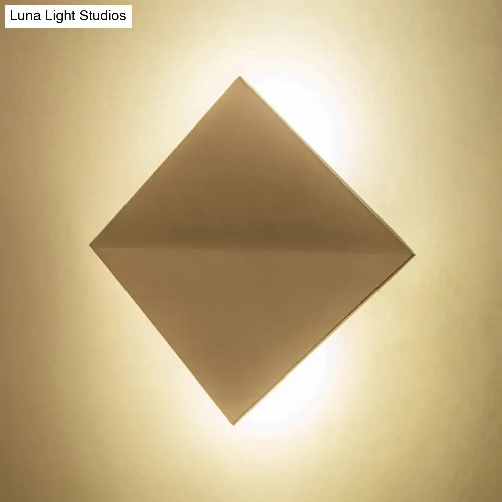 Minimalist diamond-shaped wall sconce with warm matte metallic finish for direct wired electric living space lighting