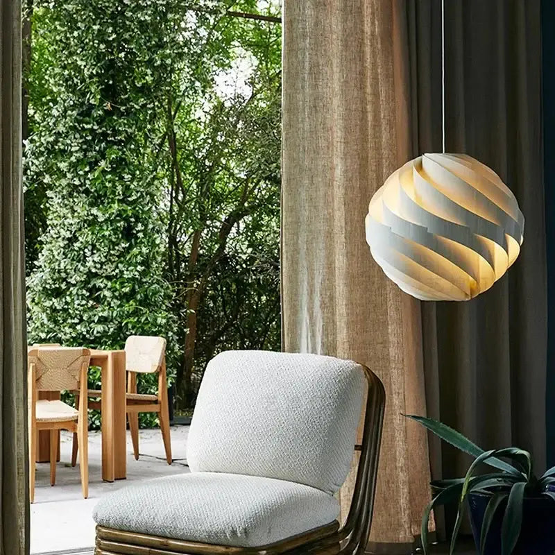 Modern white swirling spherical pendant light with ribbed design and warm illumination for dining room decorbites designer pendant