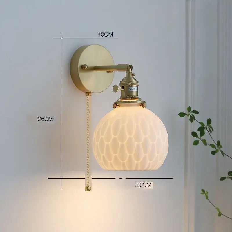 Gold-toned wall sconce with frosted honeycomb glass shade and adjustable arm pairs with decorbites ceramic led pendant lights