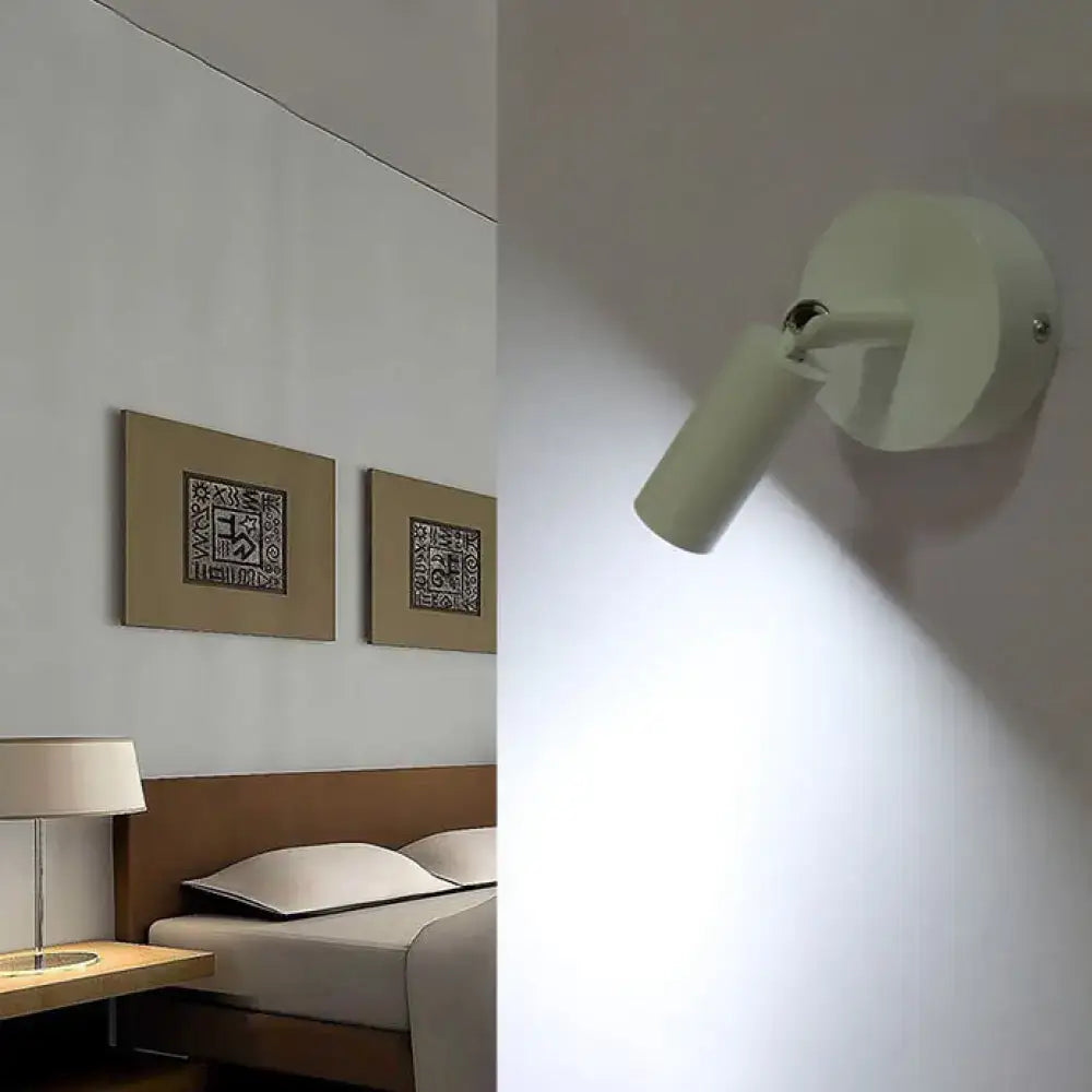 Off-white wall-mounted white tube wall light with sleek cylindrical head and circular base for modern bedroom lighting