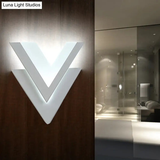 Modern white v-shaped wall sconce with layered geometric design.
