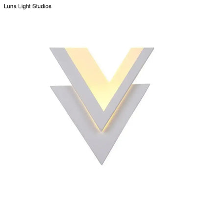 Modern white v-shaped led wall mounted light with matte geometric panels and warm yellow led wall strip illumination