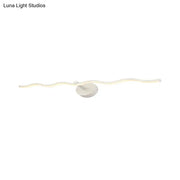 Modern white wave vanity light led wall sconce with a sleek wavy design and circular base for bathroom use