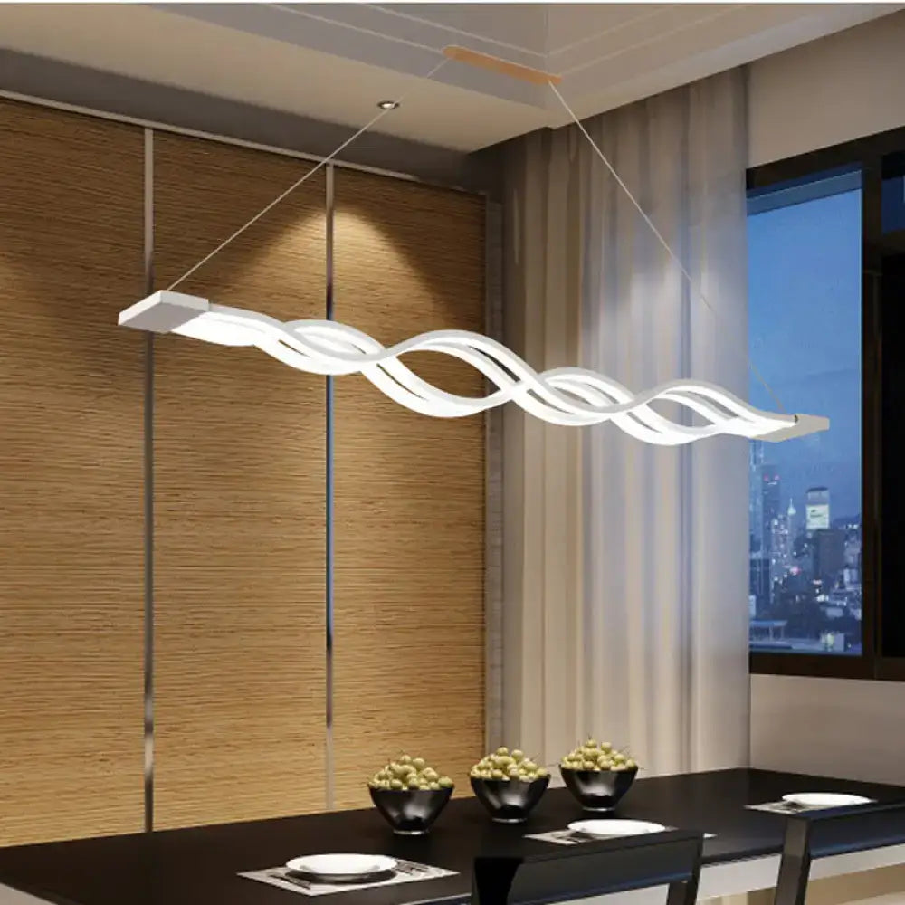 Modern white wave led pendant light with sleek twisted design hanging above room island dining table