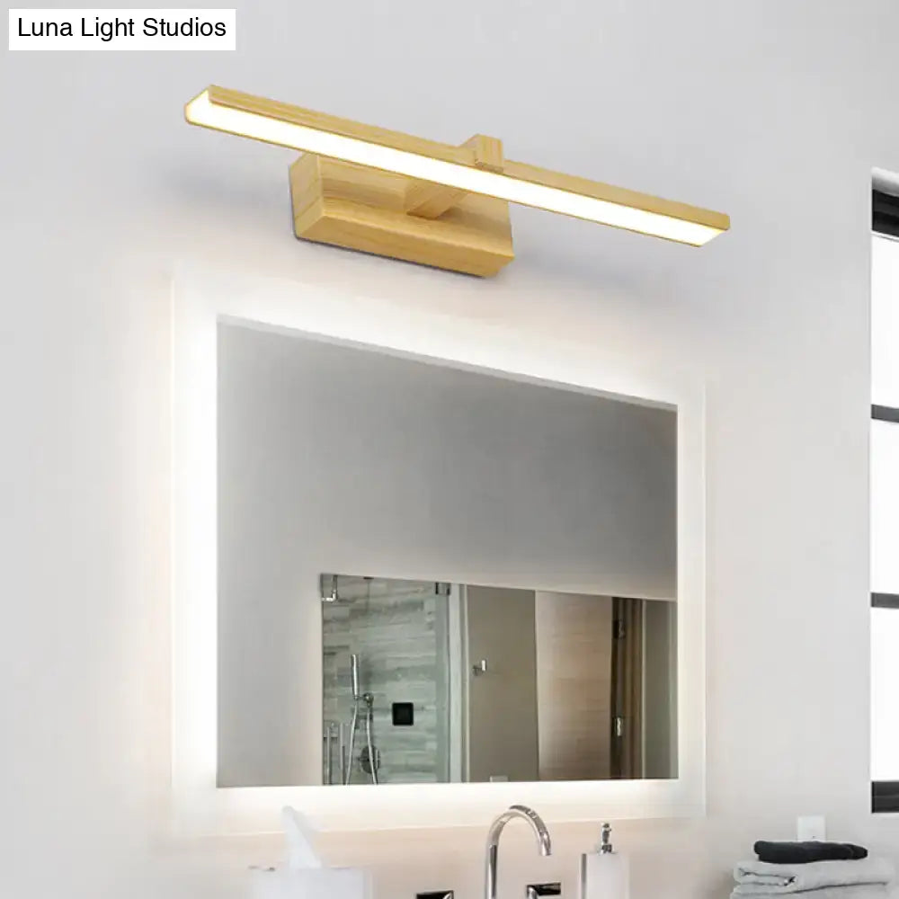 Gold-finished modern wooden vanity light with white wood accents mounted above a bathroom mirror