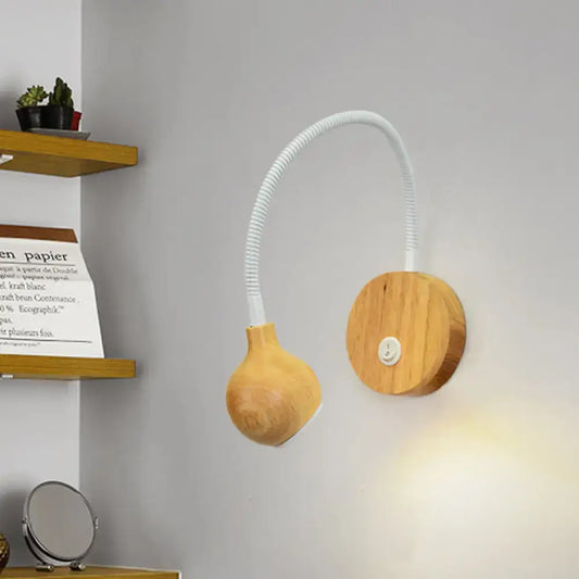 Wooden wall light with adjustable arm, white flexible gooseneck, and rounded light-emitting head for bedroom reading