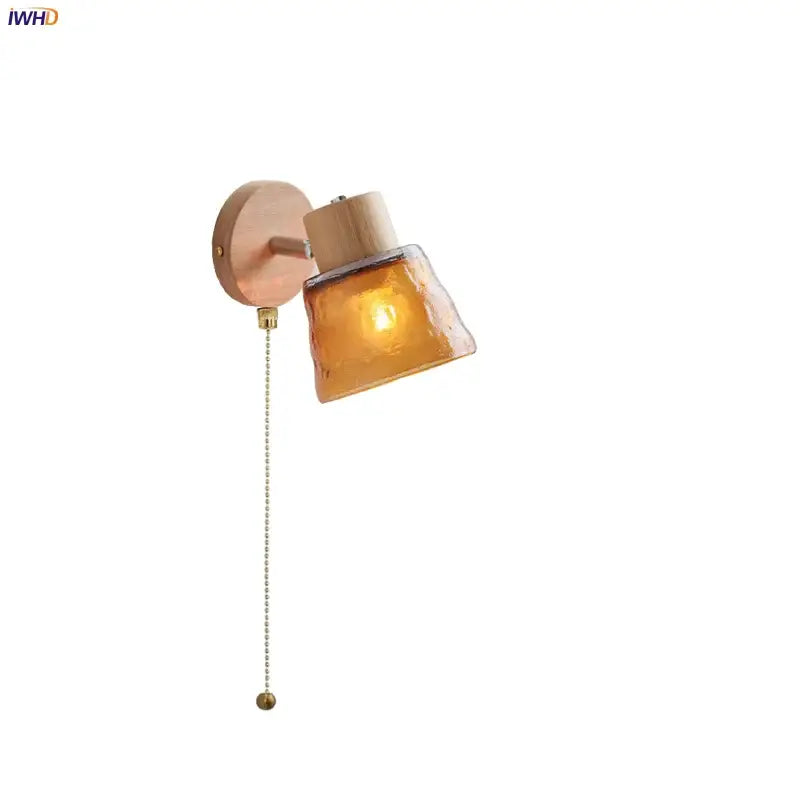 Modern wood and amber glass led wall sconce with warm amber glass decorbites and brass pull chain for bedroom lighting