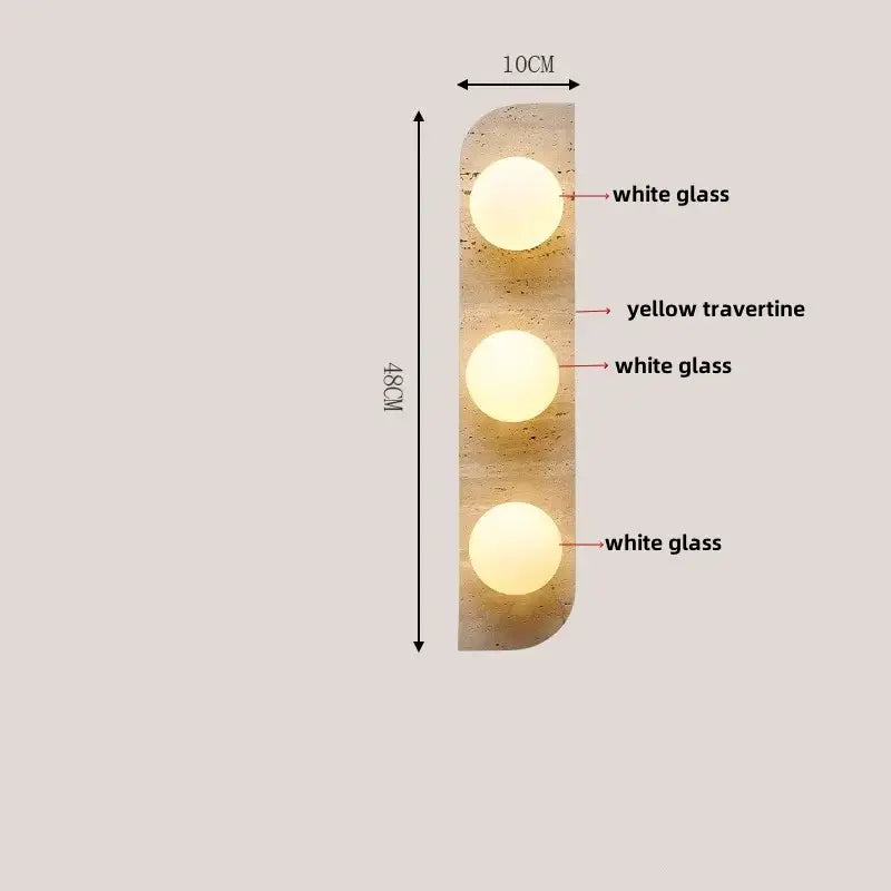 Modern wood and black iron wall light fixture with three illuminated white glass spheres on yellow travertine panel