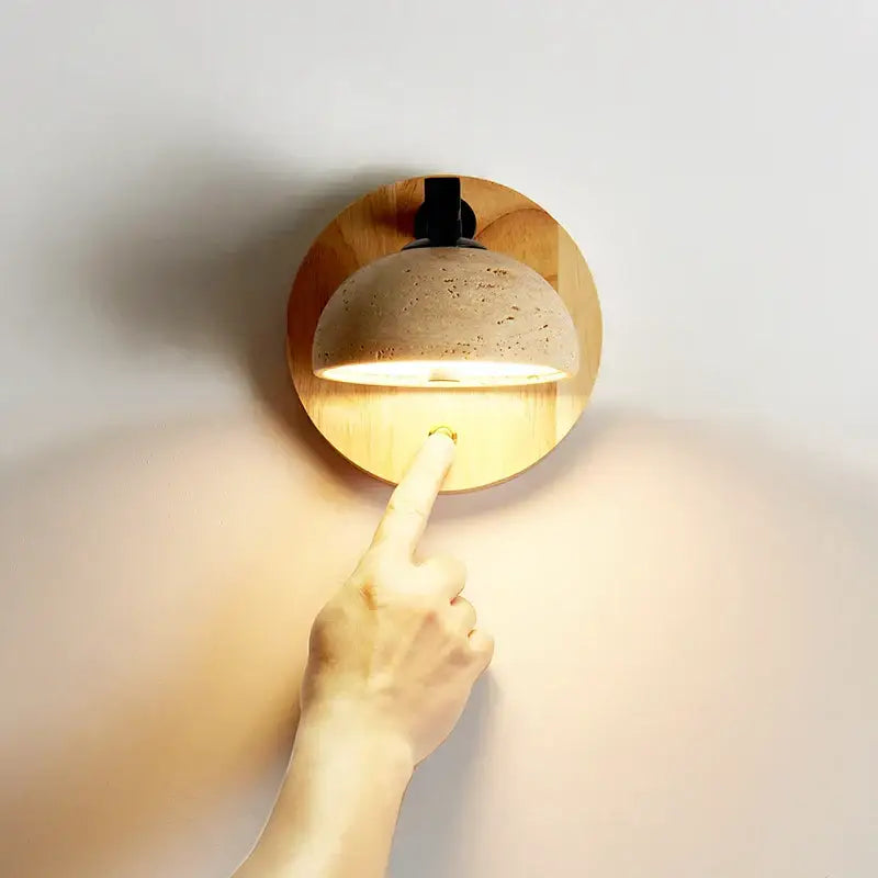 Modern wood and black iron wall light fixture with warm-toned dome and textured cork finish for bedroom sconce use