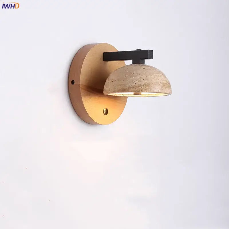 Modern wall light fixture with warm wood backplate, black iron arm, and beige concrete shade for bedroom use