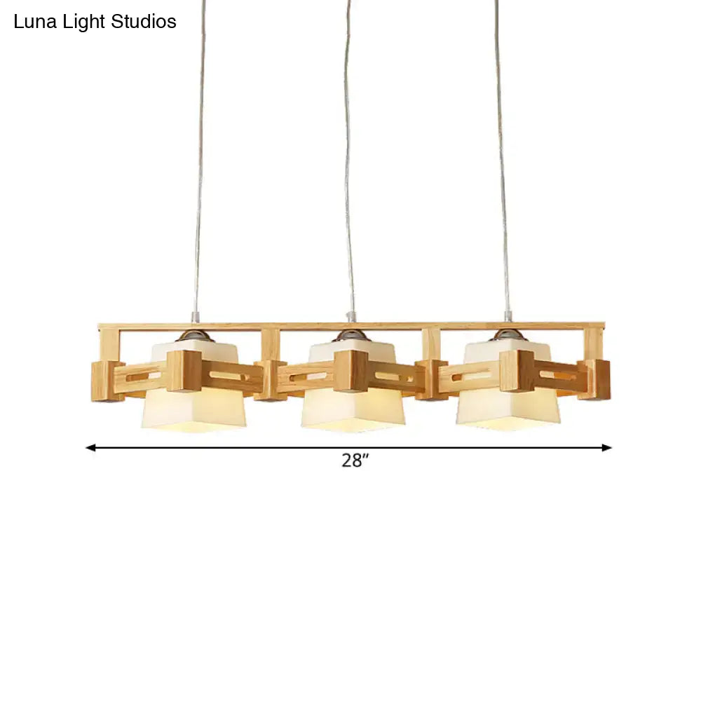 A modern wooden pendant light fixture with three beige milk frosted glass shades for frosted glass island lighting