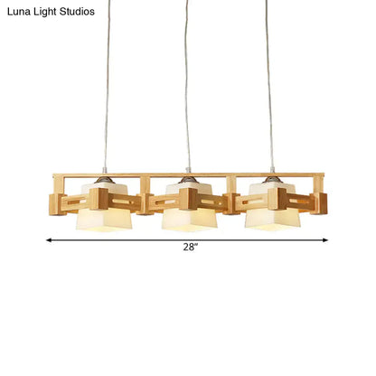 A modern wooden pendant light fixture with three beige milk frosted glass shades for frosted glass island lighting
