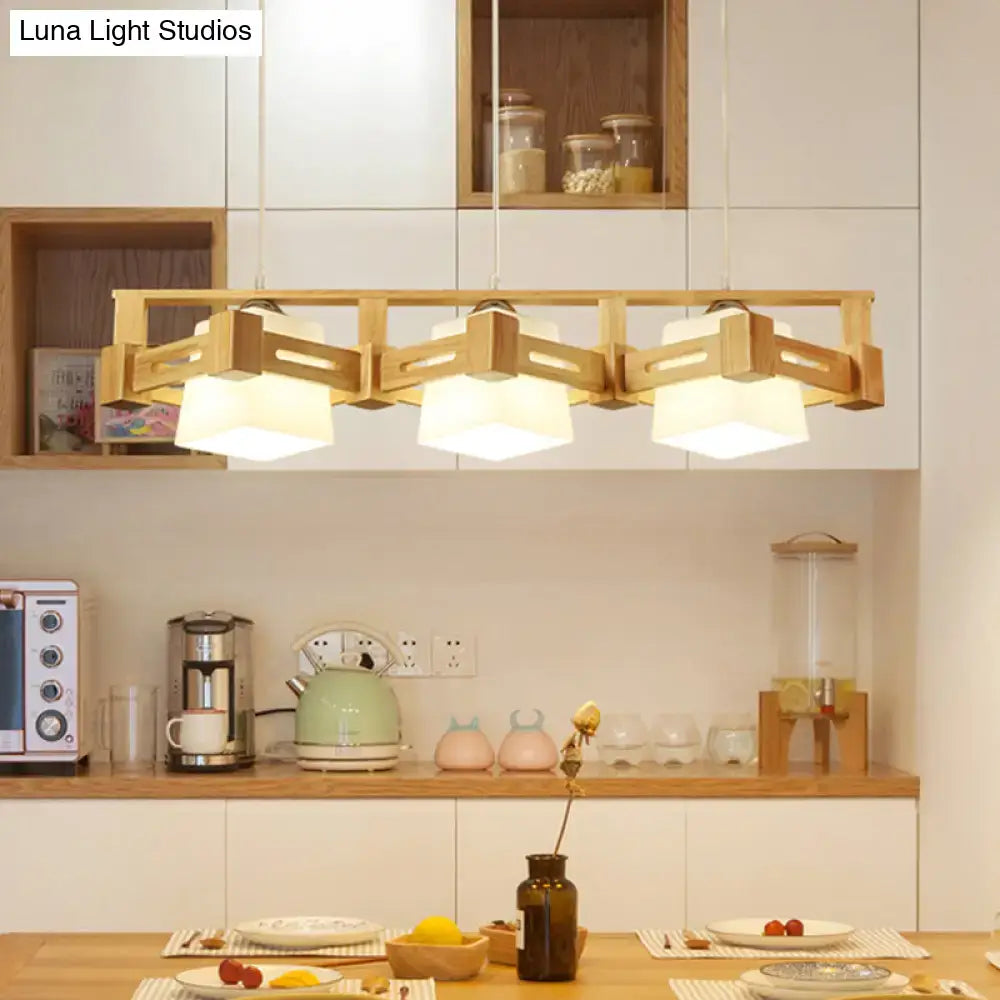 Lightweight wooden pendant light with modern geometric design and three warm white fabric shades featuring frosted glass island style