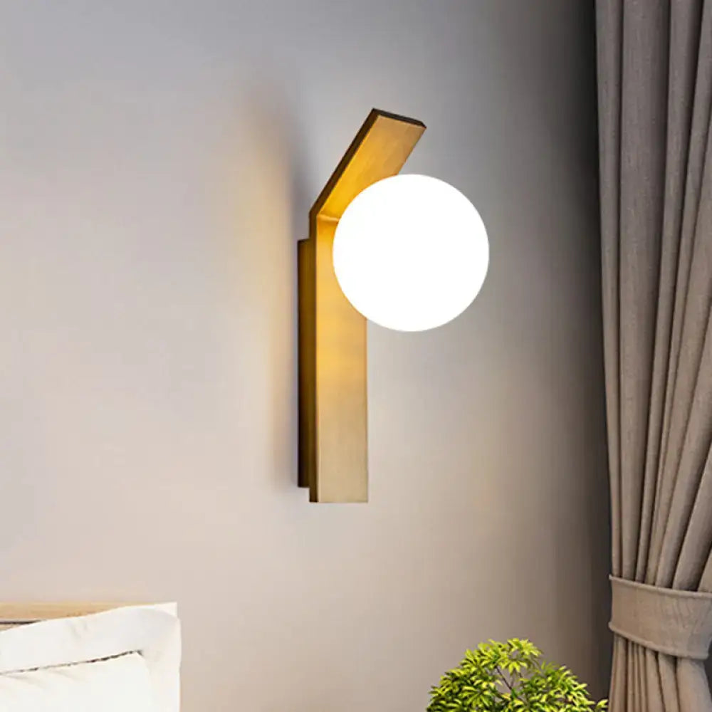 Modern wood and milk glass shade wall sconce with gold-toned geometric frame and frosted milk glass globe for dining room