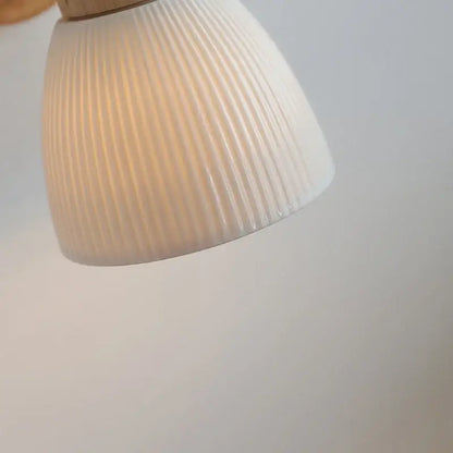 Modern wood and ribbed glass wall light fixture featuring an off-white ribbed ceramic lampshade with a glossy finish