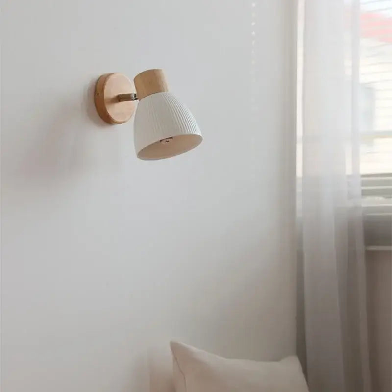 Minimalist wall light fixture with natural wood base and white ribbed ceramic shade for modern bedroom use