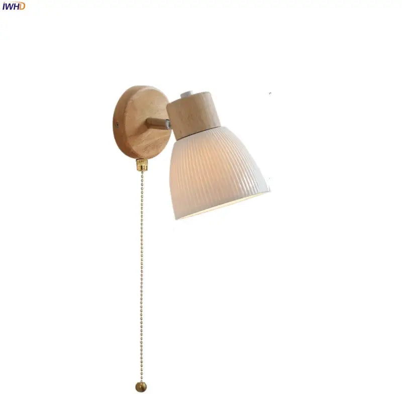 Minimalist wall light fixture with natural wood base, ribbed off-white glass shade, and brass pull chain for bedrooms