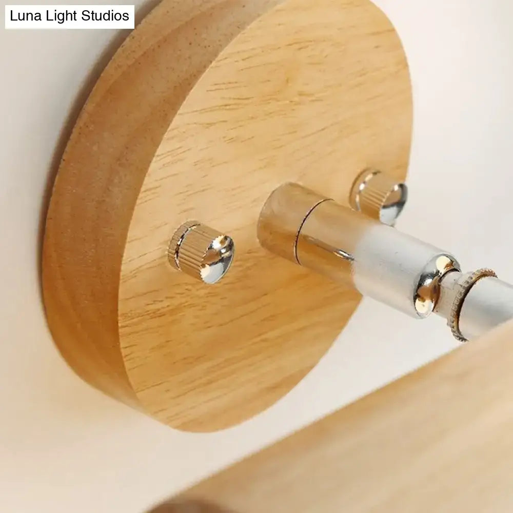 Modern wood and white glass ball rotating wall sconce with light wood circular mount and silver metal hardware