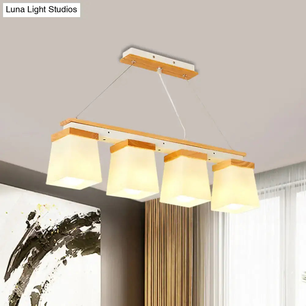 Modern rectangular pendant light with four warm square shade white lights on natural wood frame for dining room use