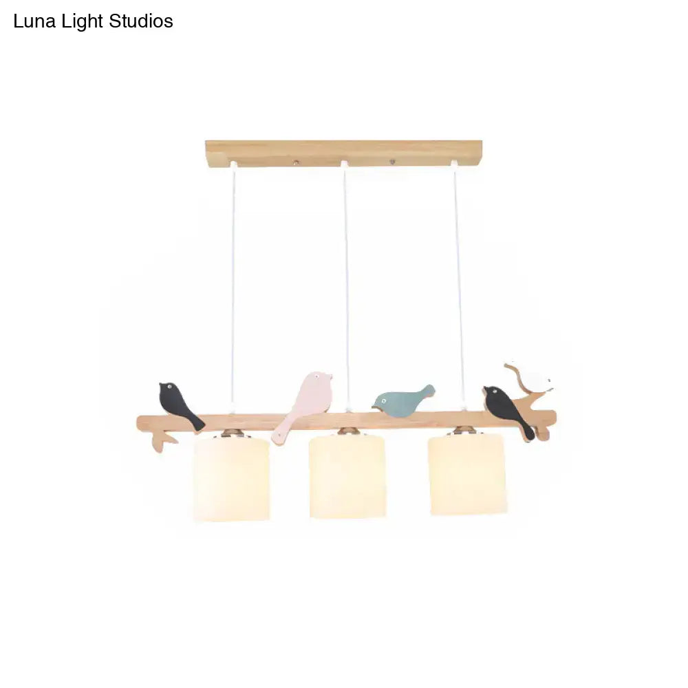 A wooden pendant light with three frosted glass shades and bird accents ideal for kitchen island or barrel island lighting