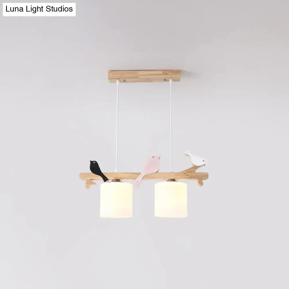 Wooden branch-style pendant light with three painted birds and two frosted glass shades for kitchen island or barrel island