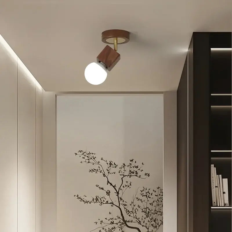 Modern ceiling light with warm wood finish and brass accents featuring adjustable white globe bulb decorbites cube wood copper