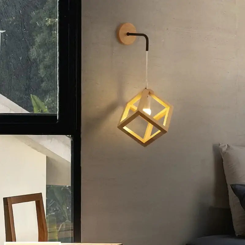 A warm-toned wooden cube led wall light with black curved arm and circular mount for modern bedroom wall lights