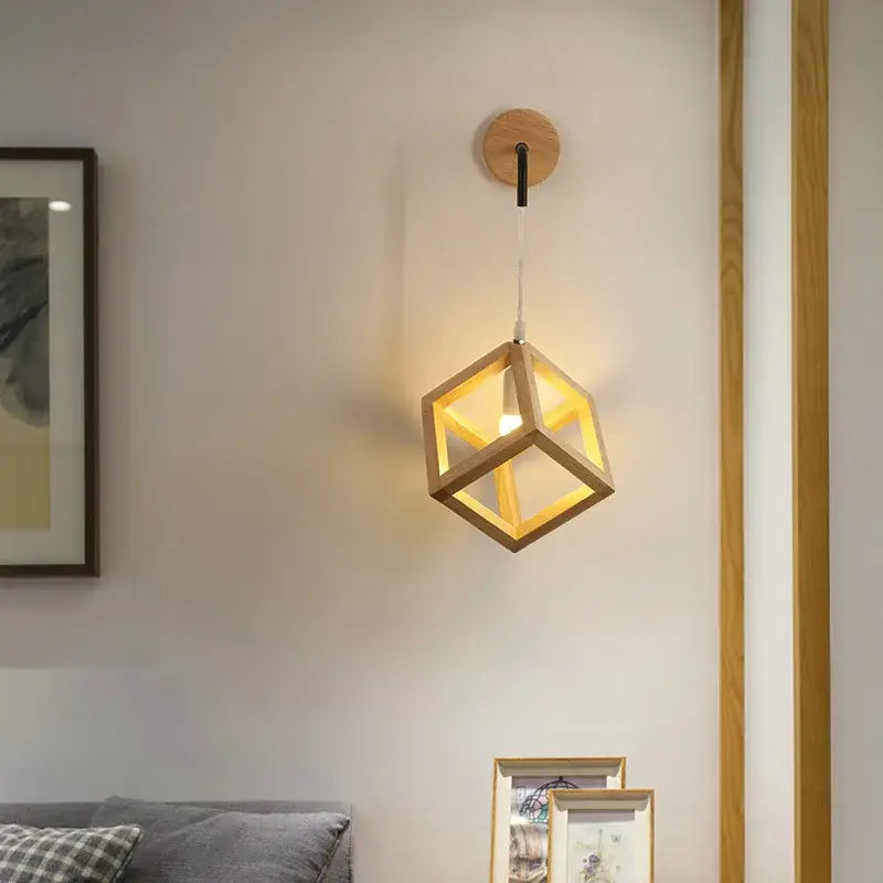 A warm-toned wooden cube led wall light with minimalist design suspended from a circular wood base for bedroom use