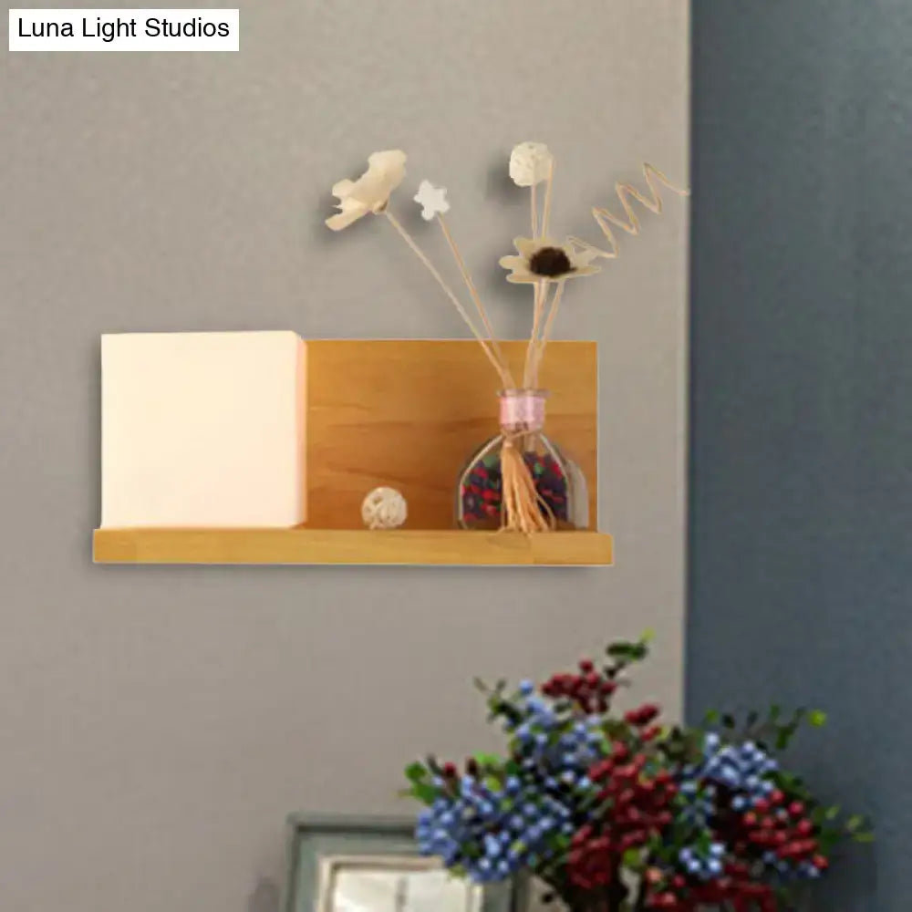 Modern wood floating shelf with beige wall lamp sconce light holding a glass diffuser and dried flowers for bedroom use