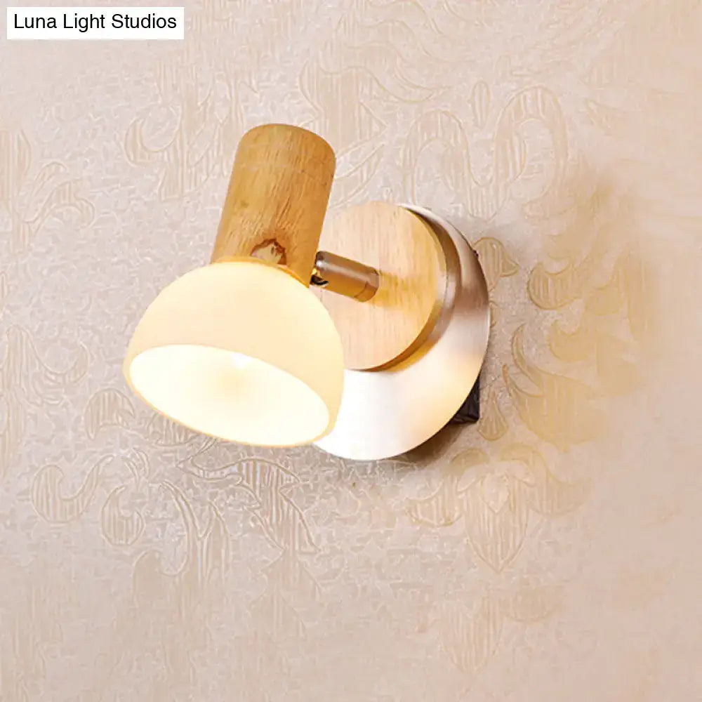 Modern wood sconce with warm-toned wooden base and milk white glass shade for bedroom wall lighting