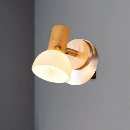 Modern wood sconce with warm-toned wooden base and milk white glass shade for bedroom wall lamp lighting