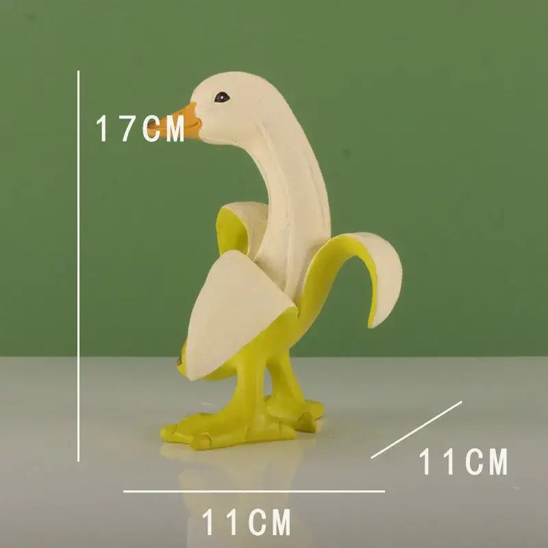 A whimsical white and yellow duck figurine with a banana peel body standing 17cm tall resembling a banana balloon dog sculpture