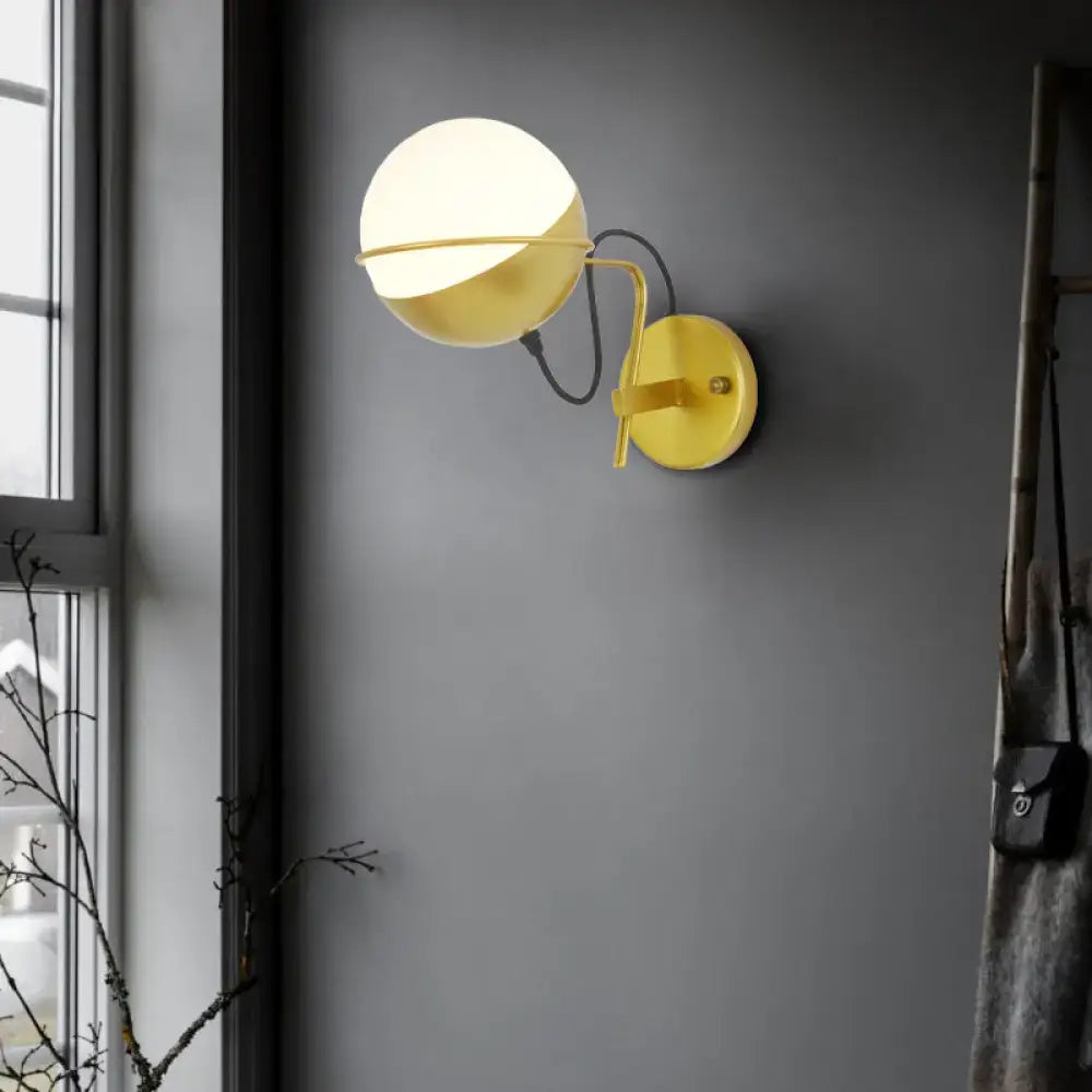 Modern yellow globe wall sconce with matte glass light and curved metal arm for bedroom use