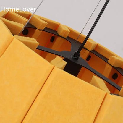 Modern yellow pleated fabric felt pendant light with yellow acoustic foam panels and black metal frame for dining room
