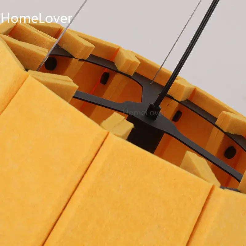 Modern yellow pleated fabric felt pendant light with yellow acoustic foam panels and black metal frame for dining room