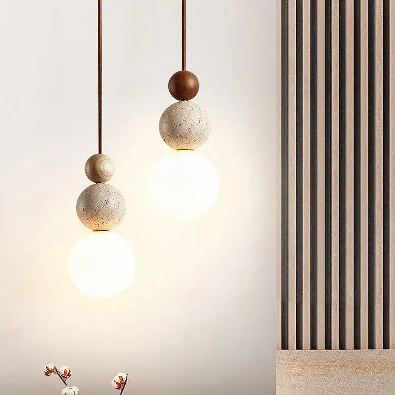 Modern yellow travertine and wood led bulb pendant light with stacked concrete spheres and warm glow for kitchen use