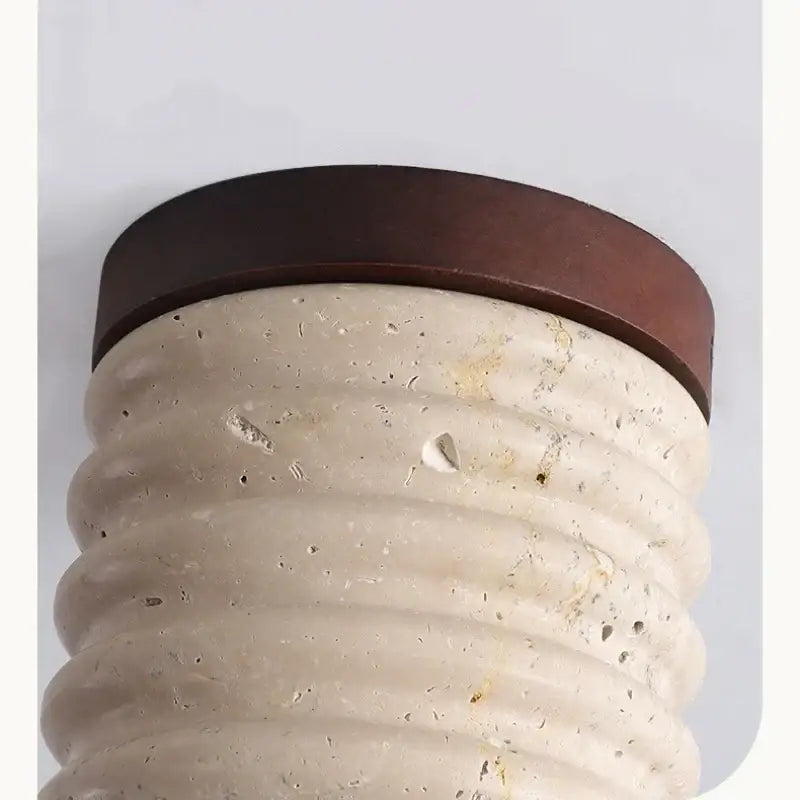 Beige textured stone column with dark brown metal cap under modern yellow travertine ceiling light decorbites led wood design