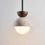 Modern yellow travertine led pendant light with textured concrete dome dark wood cap and frosted glass globe for kitchen island