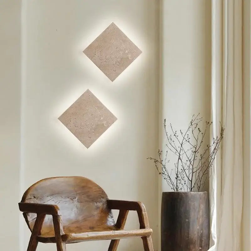 Two beige yellow travertine square led wall lamp sconces with textured surface and integrated backlighting for stairs