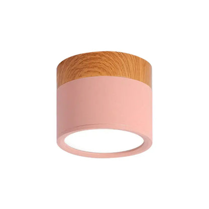 A decorbites™ small macaron metal flush mount ceiling light with pink matte finish and natural wood top for kitchen bar