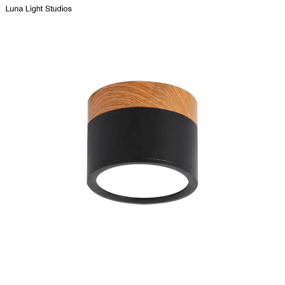 Modern cylindrical decorbites flush mount ceiling light with black metal body and warm wooden top for kitchen bar