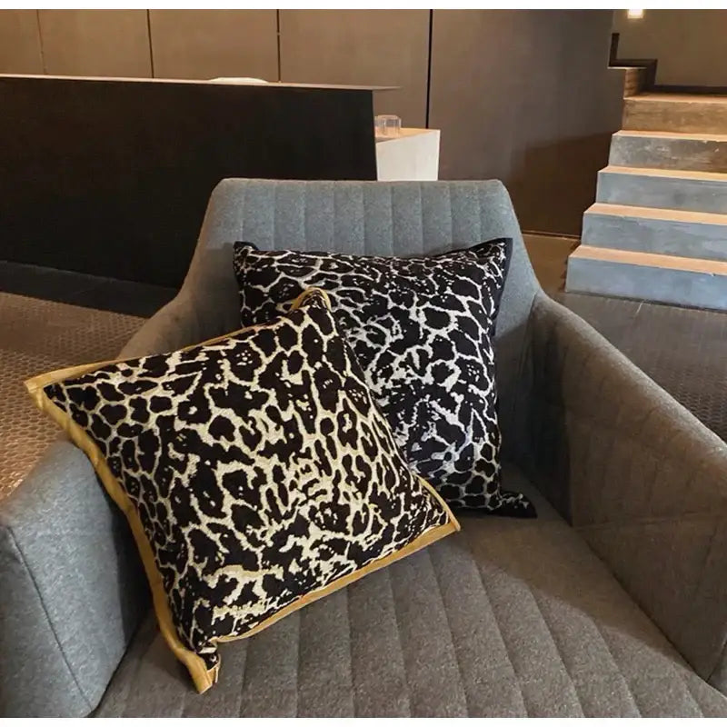 Two square pillow covers with leopard and zebra pattern in black cream featuring decorbites gold zebra trim for living room decor
