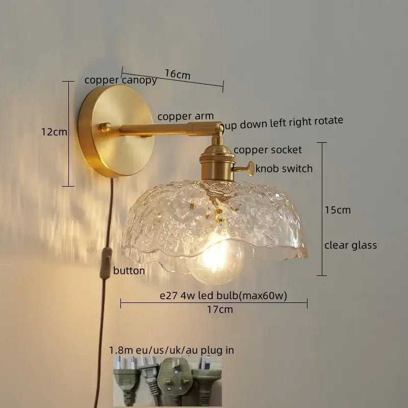 A vintage-style wall lamp with brass-finished copper arm and ornate clear glass led shade with bubble texture