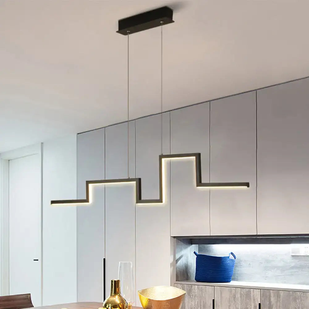 Modern black linear metal hanging light fixture with illuminated zigzag design above dining area