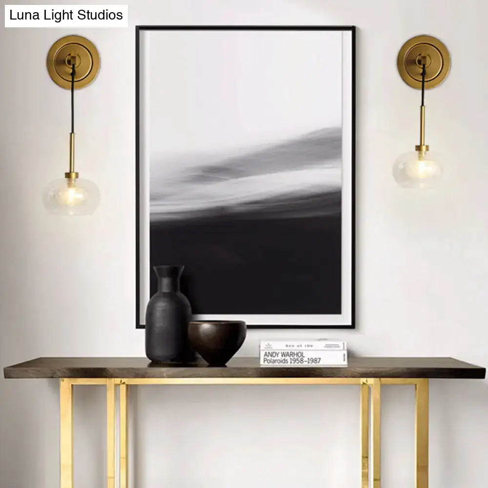 Black matte ceramic vase with slender neck beside matching bowl on console table near amber white glass bedroom lamp