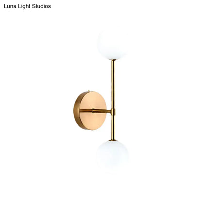 Modernist black gold wall sconce with gold finish and two frosted glass globe shades for living room lighting