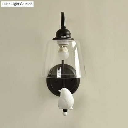 Modernist black metal cone wall lamp with clear glass bell shade and white ceramic bird figurine for bedroom use