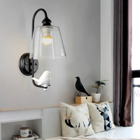 Modernist black metal cone wall lamp with clear glass shade and attached white bird figurine for bedroom use